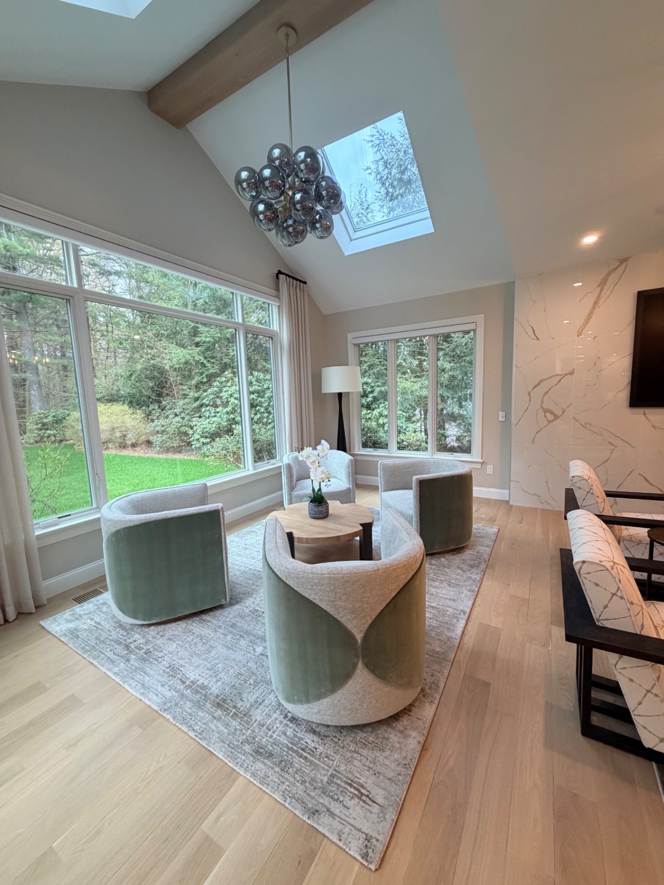 Vaulted sunroom with swivel chairs and skylight
